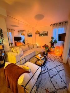 un soggiorno con divano e tavolo di Le Clara Chic - 1 Chambre - Balcon - 4 Personnes - Cosy a Boulogne-Billancourt