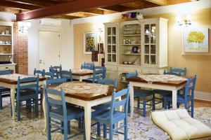 ein Esszimmer mit Tischen und blauen Stühlen in der Unterkunft Ferienwohnung für 4 Personen ca 70 m in Giungano, Kampanien Cilento in Giungano