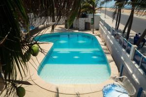 a large blue swimming pool next to a beach at Tahiti Hotel in Cotonou