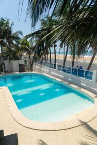 a swimming pool with a beach in the background at Tahiti Hotel in Cotonou