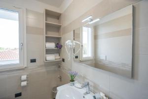 een badkamer met een wastafel en een spiegel bij Ferienwohnung für 2 Personen ca 35 qm in Alghero, Sardinien Sassarese in Alghero
