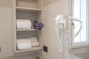 a bathroom with towels and a phone on the wall at Ferienwohnung für 2 Personen ca 35 qm in Alghero, Sardinien Sassarese in Alghero