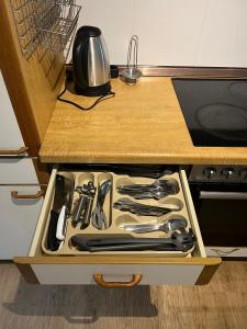 a drawer filled with cooking utensils on a counter at Apartments zum Wildgehege in Siegen