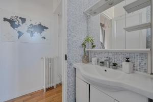 La salle de bains est pourvue d'un lavabo blanc et d'une carte du monde sur le mur. dans l'établissement Appartement spacieux avec hamac + parking gratuit, à Gentilly