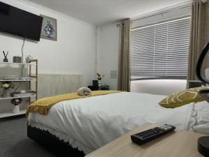 a bedroom with a bed with a television and a desk at Comfy Room in Nottingham in Nottingham