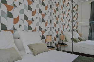 讓蒂伊的住宿－Appartement spacieux avec hamac + parking gratuit，一间带两张床的卧室和几何墙