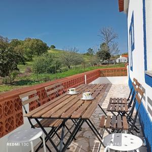 a wooden table and two chairs on a patio at Casa do Henrique in Troviscais