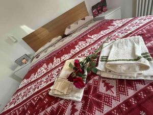 um quarto com uma cama com toalhas e flores em Appartamento al Castello em Lozzo Cadore