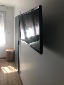 - un réfrigérateur avec une fenêtre sur le côté de la chambre dans l'établissement Appartement Chaleureux -Paris-CDG-RER B-Parc des Expos de Villepinte-Disneyland-Asterix-Stade de France-, à Vaujours