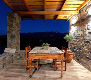 einen Holztisch und Stühle auf einer Terrasse in der Unterkunft Stone House in Sitia