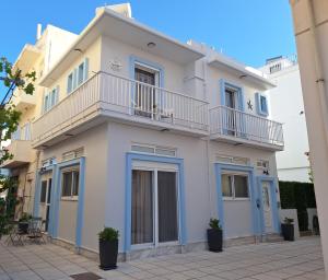 a white house with a balcony on top of it at SeaSTAR Beach Apartments in Kos Town