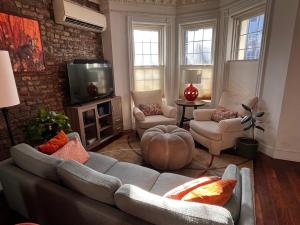 a living room with a couch and chairs and a tv at GEM of a Free-Standing Family House in Great Neighborhood in Brooklyn