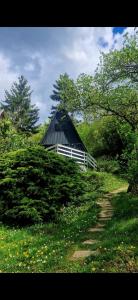 a barn sitting on top of a grassy hill with a path at Albatross in Dömös