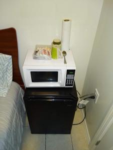 a microwave sitting on top of a dresser next to a bed at Two Bedroom Apartment - North East Bronx in Bronx