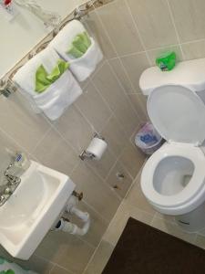 a bathroom with a toilet and a sink and towels at Two Bedroom Apartment - North East Bronx in Bronx