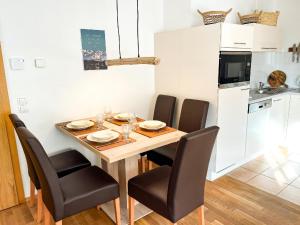 cocina y comedor con mesa y sillas en Ferienwohnung für 4 Personen ca 55 qm in Rauris, Salzburger Land Rauristal, en Rauris