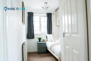 Habitación pequeña con cama y ventana en Elegant 3 bed apartment Luton, en Luton