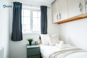 sypialnia z łóżkiem i oknem w obiekcie Elegant 3 bed apartment Luton w Luton