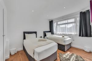 a bedroom with two beds and a window at Relaxed Home in Eltham