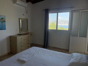 um quarto com uma cama com um espelho e uma janela em Sun n' Blue Villas em Sarandë