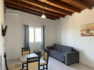 uma sala de estar com um sofá e uma mesa em Sun n' Blue Villas em Sarandë