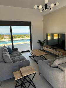 a living room with two couches and a flat screen tv at Villa Elaia in Sitia