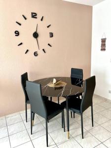 una sala da pranzo con tavolo e orologio sul muro di Moderne Wohnung bei BASF a Hörlitz