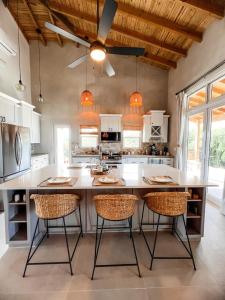 a kitchen with a large white island with chairs at Paradise Cove home in Gregory Town