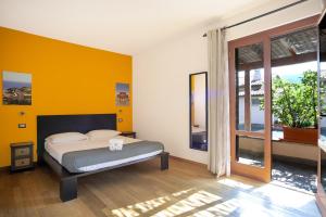 een slaapkamer met een bed en een gele muur bij Agriturismo La Sassicaia in Castiglione della Pescaia