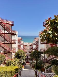 a building with red stairs and the ocean in the background at El Bikini Cullera - Junto a la playa - Right on the beach in Cullera +34 photos