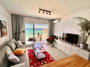 a living room with a couch and a television at El Bikini Cullera - Junto a la playa - Right on the beach in Cullera