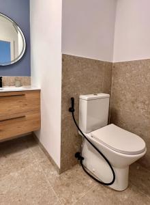 a bathroom with a toilet and a mirror at El Bikini Cullera - Junto a la playa - Right on the beach in Cullera +34 photos