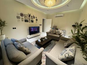 sala de estar con sofás y TV de pantalla plana. en شقة فاخرة غرفة وصالة بالعارض دخول ذاتي ١٠, en Riad