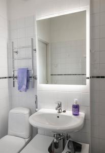 bagno con lavandino, servizi igienici e specchio di Design stay in the heart of Punavuori a Helsinki
