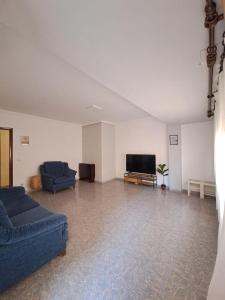 a living room with two blue couches and a flat screen tv at Gabriella Apartment Near the beach in Puerto de Sagunto