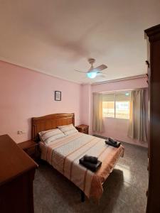 Un dormitorio con una cama y un ventilador de techo. en Gabriella Apartment Near the beach, en Puerto Sagunto