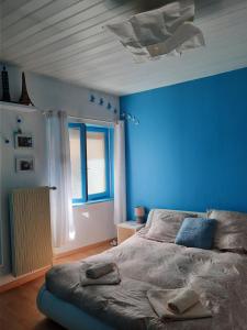 um quarto azul com uma cama e uma parede azul em Maison de charme avec terrasse et garage fermé proche des volcans em Royat
