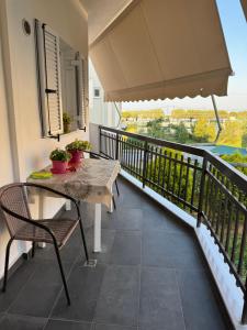 a balcony with a table and chairs and a view at Zoe Akrata Apartment in Paralía Akrátas