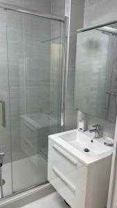 a white bathroom with a shower and a sink at Un studio de luxe Les Champs Elysées in Paris