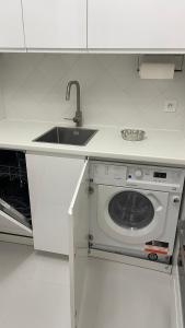 a kitchen with a sink and a washing machine at Un studio de luxe Les Champs Elysées in Paris