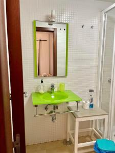 a bathroom with a green sink and a mirror at Casa Mate Cotillo Mar in Cotillo