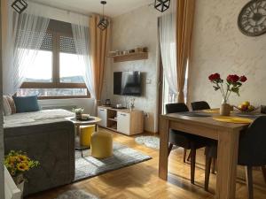 兹拉蒂博尔West Residence - Panorama lux & Spa的一间带床和桌子的客厅以及一间用餐室