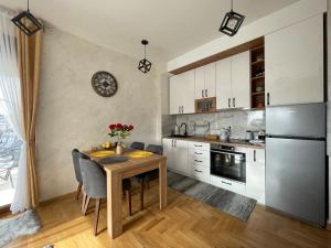 兹拉蒂博尔West Residence - Panorama lux & Spa的配有桌椅和冰箱的厨房