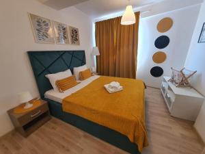 Dormitorio pequeño con cama con colcha amarilla en Apartament Fundeni, en Bucarest