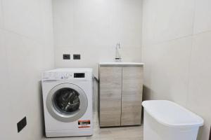 una lavanderia bianca con lavatrice di villa dei cento Pini a Monteroni di Lecce