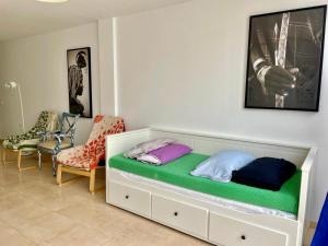 un letto con cuscini sopra in una stanza con sedie di Casa Mate Cotillo Mar a Cotillo