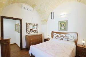 una camera con letto, cassettiera e specchio di villa dei cento Pini a Monteroni di Lecce