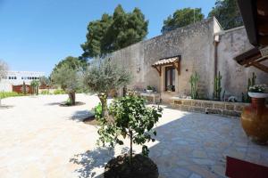 cortile in pietra con albero di fronte a un edificio di villa dei cento Pini a Monteroni di Lecce