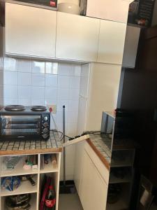 a small kitchen with a stove and white cabinets at Fine living apartment in Vredendal