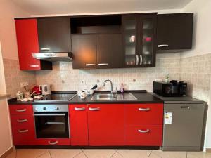 een keuken met rode kasten en een wastafel bij Dua Al Mar With Parking Garage in Rovinj